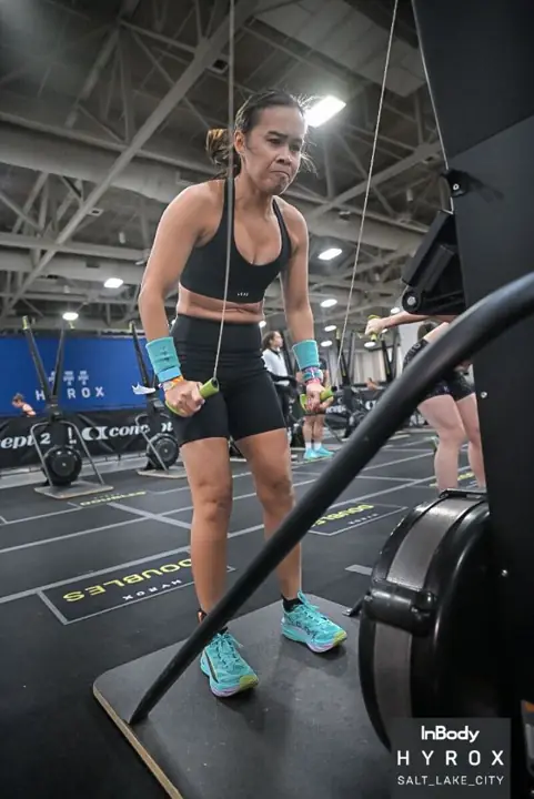 Dr. Tran training on a rowing machine at a HYROX race